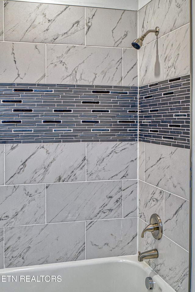 room details with tiled shower / bath combo