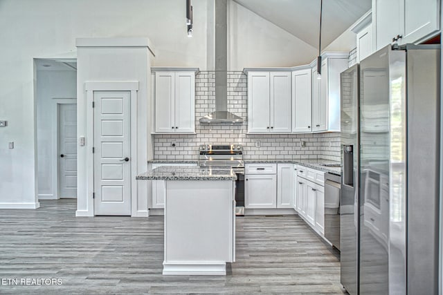 kitchen with white cabinetry, light stone counters, light hardwood / wood-style floors, pendant lighting, and appliances with stainless steel finishes