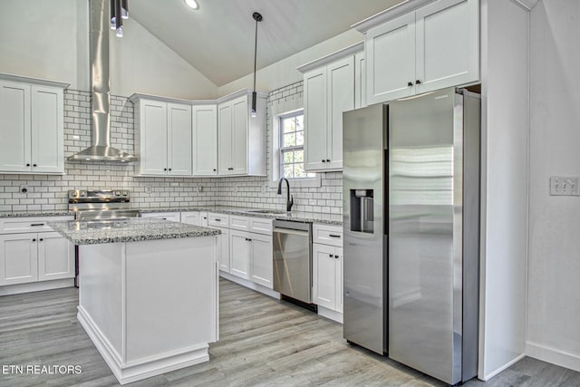 kitchen with vaulted ceiling, light stone countertops, appliances with stainless steel finishes, tasteful backsplash, and decorative light fixtures