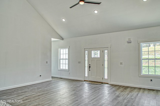 entryway featuring hardwood / wood-style flooring, high vaulted ceiling, and ceiling fan