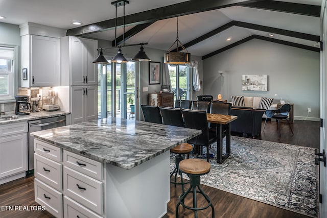 kitchen with lofted ceiling with beams, light stone countertops, decorative light fixtures, dark hardwood / wood-style flooring, and white cabinetry