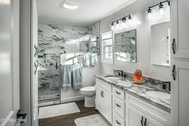 bathroom featuring hardwood / wood-style flooring, vanity, toilet, and a shower with door