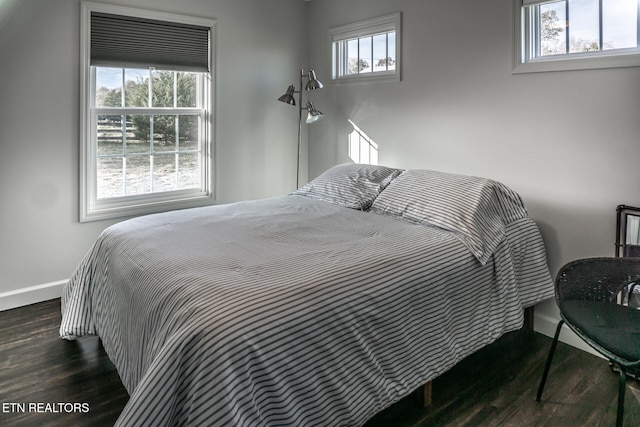 bedroom with dark wood-type flooring