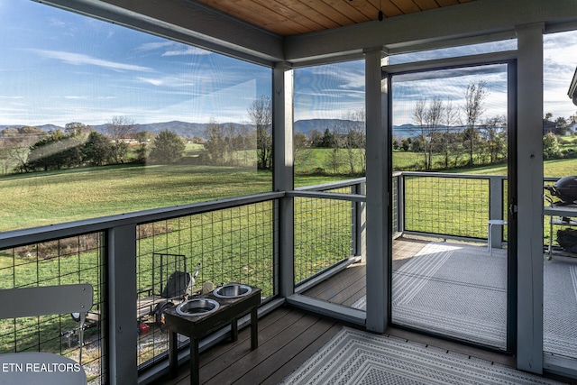 unfurnished sunroom with a mountain view and wood ceiling