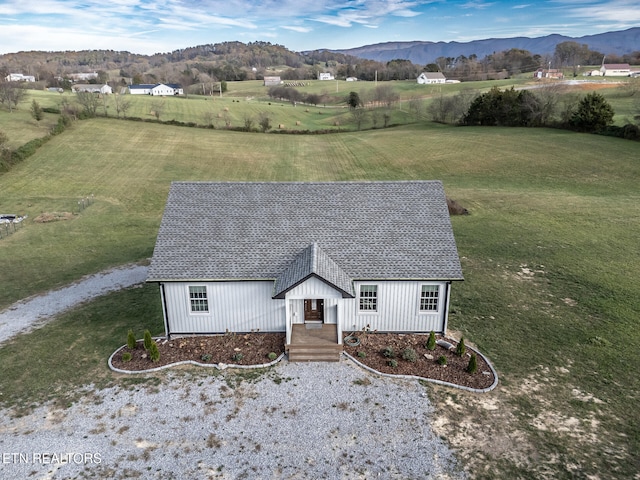 view of front of house with a mountain view, a rural view, and a front yard