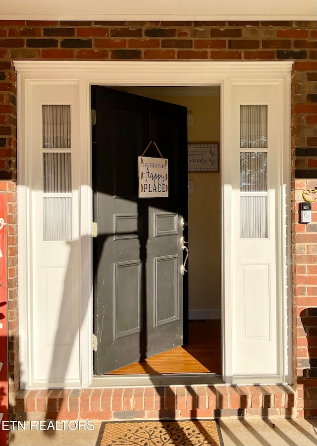 doorway to property with brick siding