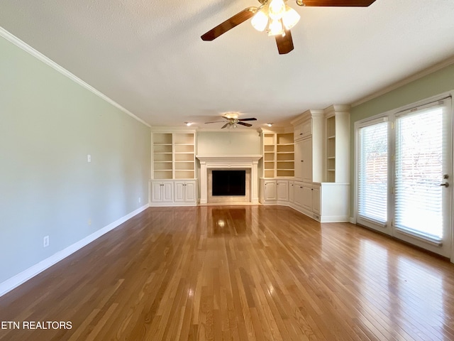 unfurnished living room featuring a fireplace, crown molding, baseboards, and wood finished floors