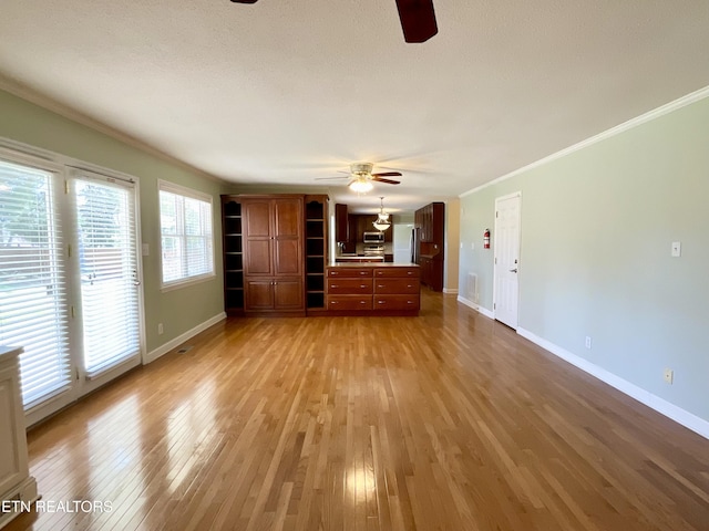 unfurnished living room featuring a ceiling fan, baseboards, light wood-type flooring, and ornamental molding