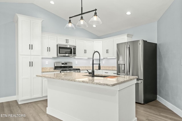 kitchen featuring sink, lofted ceiling, stainless steel appliances, and an island with sink