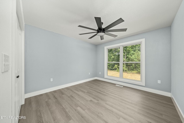 spare room with ceiling fan and light wood-type flooring