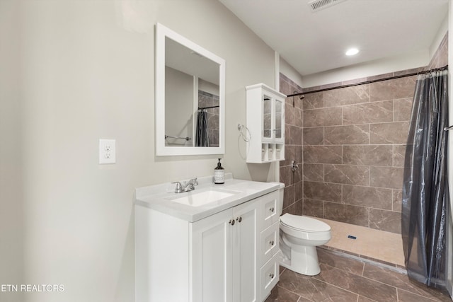 bathroom featuring a shower with shower curtain, vanity, toilet, and tile patterned floors