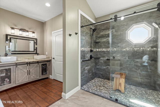 bathroom with vanity, hardwood / wood-style flooring, vaulted ceiling, and an enclosed shower