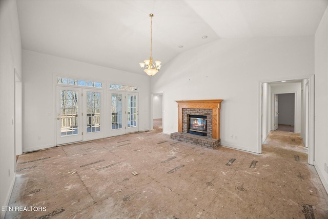 unfurnished living room with a chandelier, a fireplace, and high vaulted ceiling