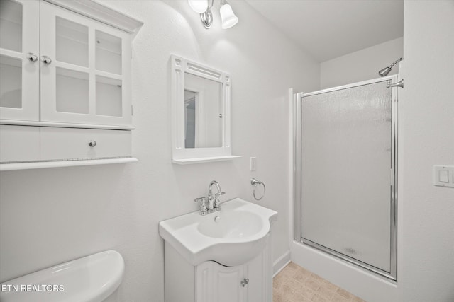 full bath featuring a stall shower, vanity, and toilet