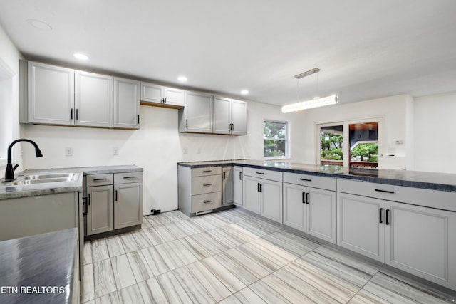 kitchen with gray cabinets, sink, and hanging light fixtures