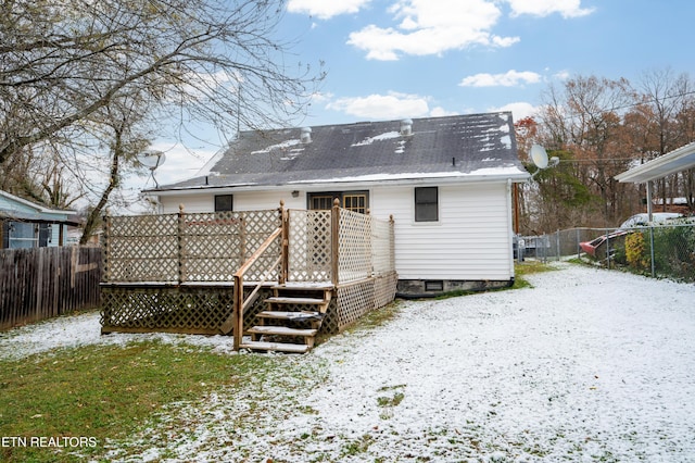 snow covered house with a deck