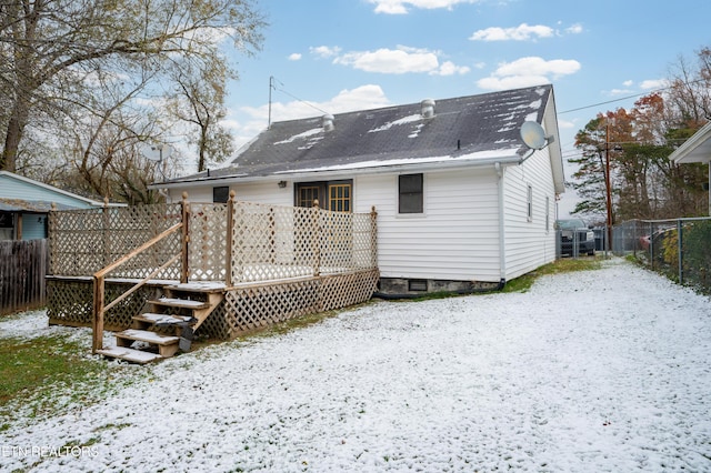 snow covered house featuring a deck