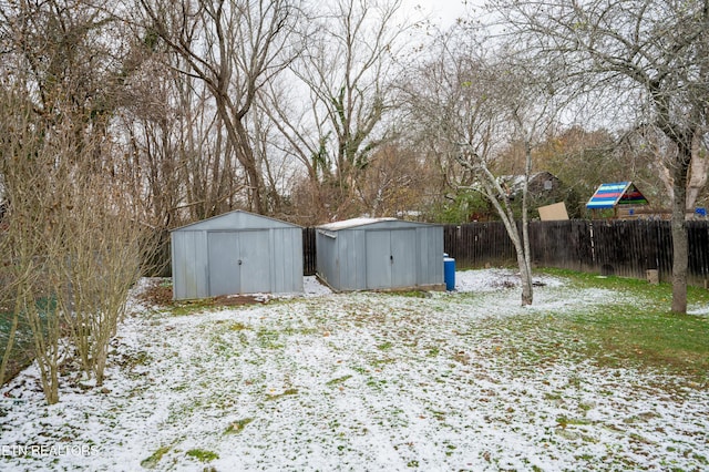 yard layered in snow with a shed