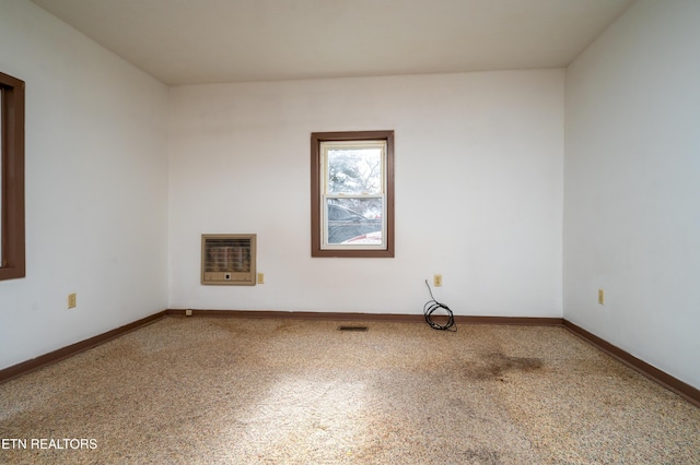 unfurnished room featuring carpet and heating unit