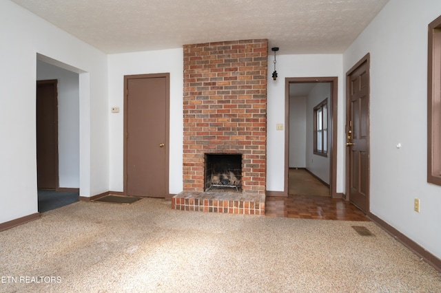 unfurnished living room with carpet flooring, a fireplace, and a textured ceiling