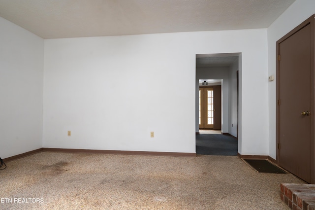 carpeted empty room with a textured ceiling