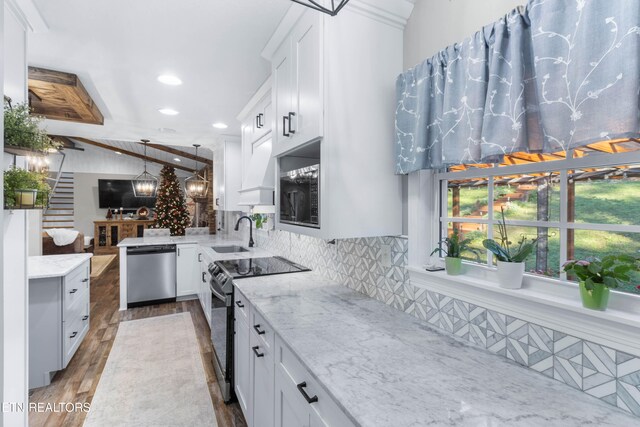 kitchen with stainless steel appliances, pendant lighting, lofted ceiling with beams, white cabinets, and dark hardwood / wood-style floors