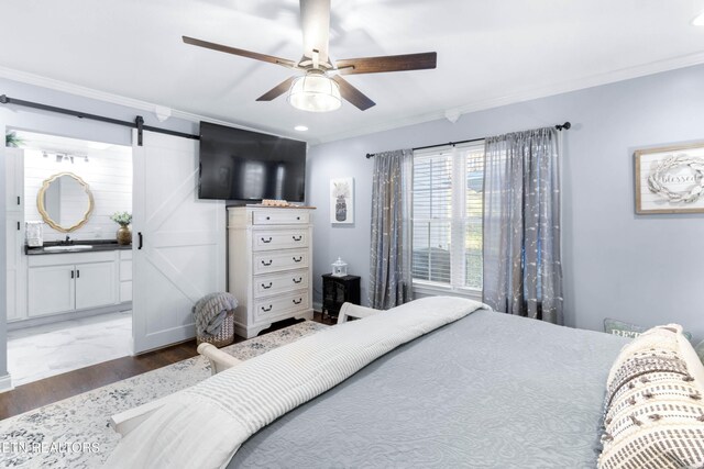 bedroom featuring a barn door, ceiling fan, sink, and crown molding