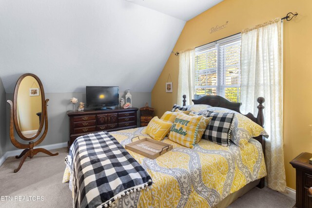 bedroom featuring light colored carpet and vaulted ceiling