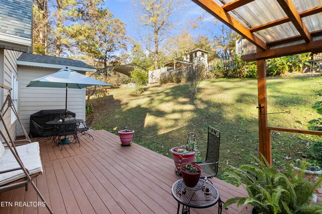 wooden deck featuring a lawn