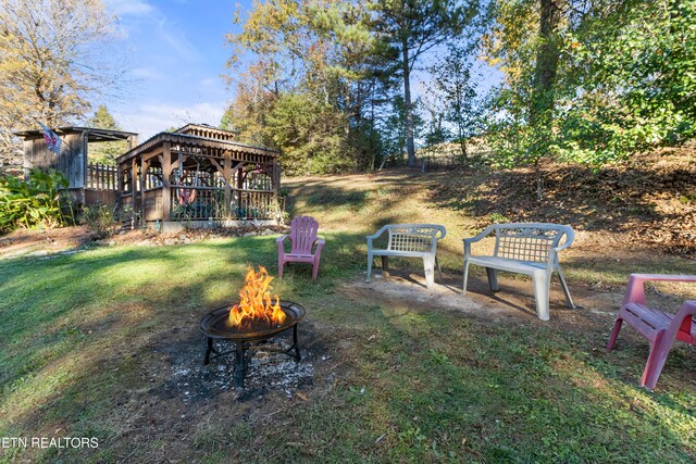 view of yard featuring a deck and an outdoor fire pit