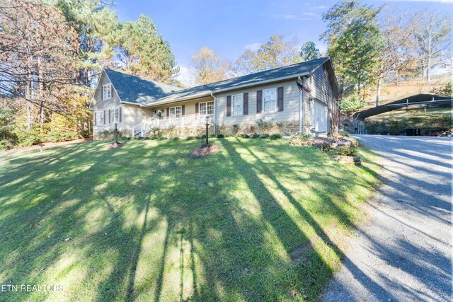 view of front of house with a carport, a garage, and a front yard