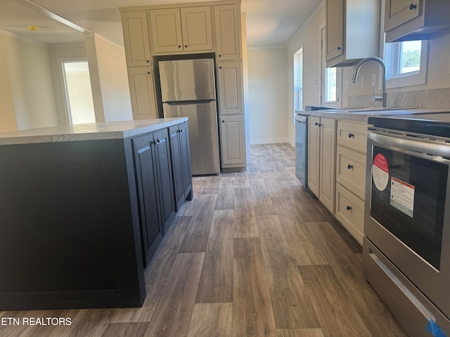 kitchen with a center island, sink, crown molding, dark hardwood / wood-style floors, and stainless steel appliances