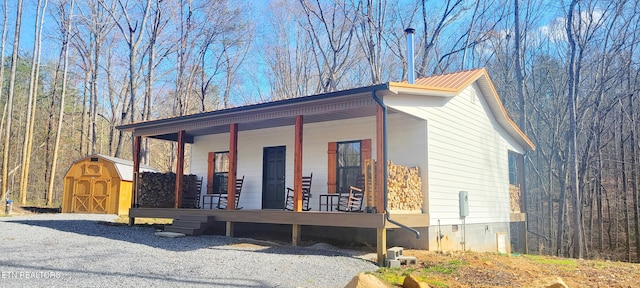 view of home's exterior featuring a porch and a storage unit