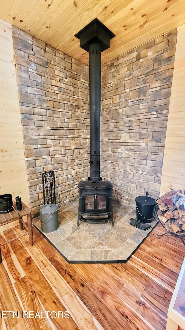 details with a wood stove, wood walls, wooden ceiling, and wood-type flooring