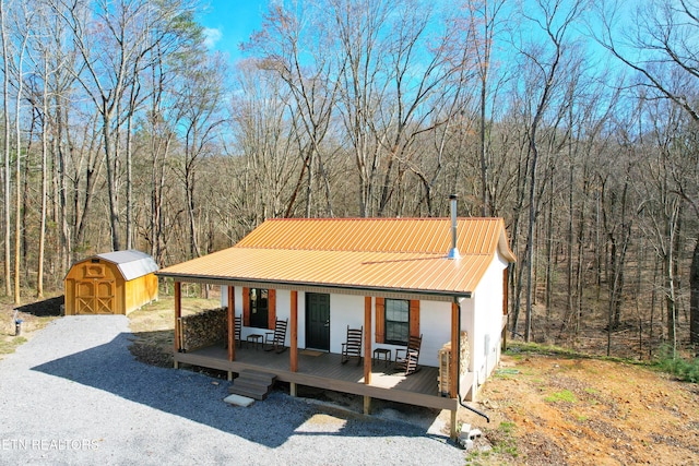 view of front of house with covered porch and a shed