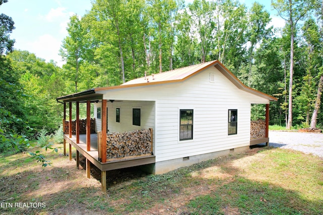 back of property featuring ceiling fan and a porch