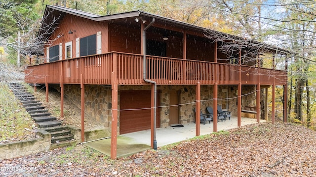 back of house featuring a deck and a patio area