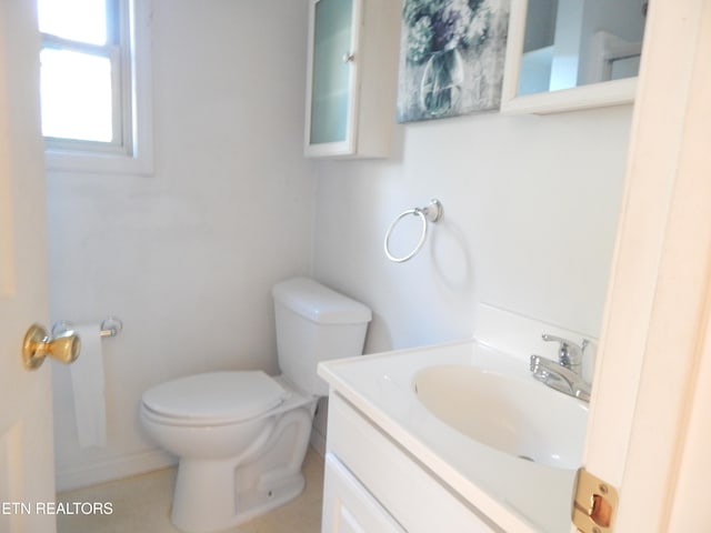 bathroom with tile patterned flooring, vanity, and toilet