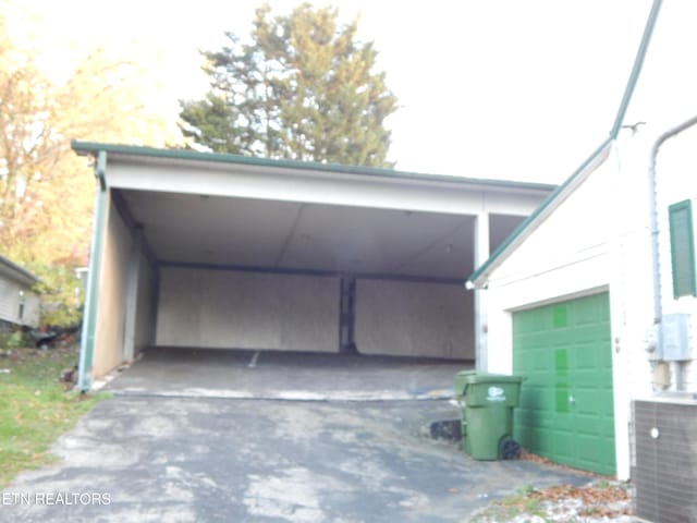 garage featuring a carport and cooling unit