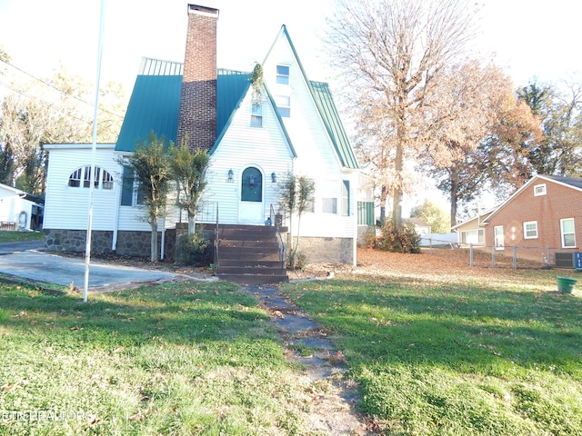 view of front of property with a front yard, central AC, and a patio area