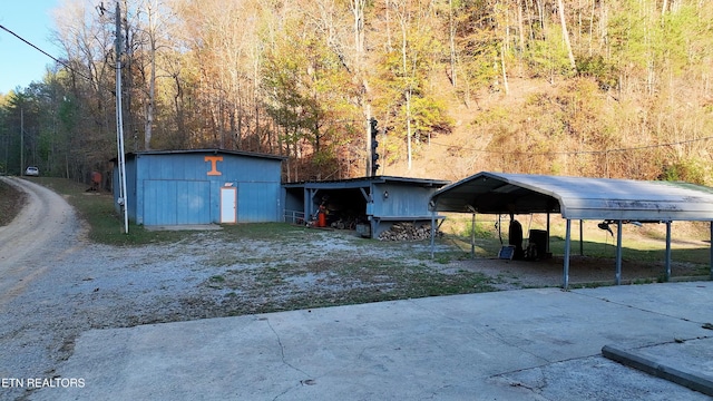 593 Cane Creek Mountain Rd, Tellico Plains, TN 37385 - exterior space featuring a detached carport, driveway, and a forest view