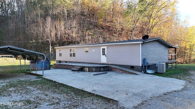 593 Cane Creek Mountain Rd, Tellico Plains, TN 37385 - back of property featuring crawl space, central AC, a view of trees, a carport, and a deck