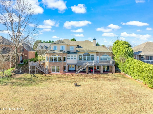 back of property with a yard and a deck