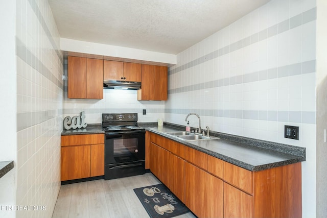 kitchen with a textured ceiling, sink, electric range, tile walls, and light hardwood / wood-style floors