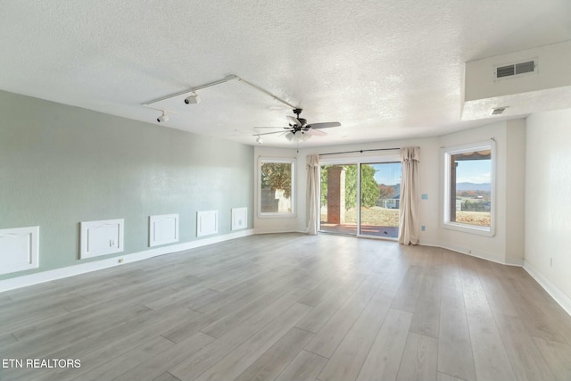 unfurnished room with ceiling fan, light hardwood / wood-style flooring, track lighting, and a textured ceiling