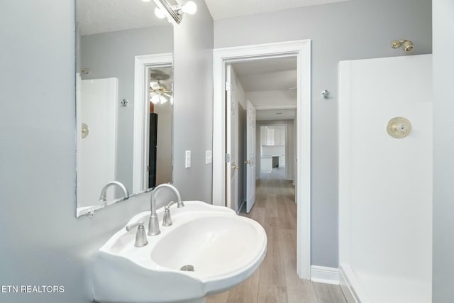 bathroom with ceiling fan, sink, and hardwood / wood-style flooring