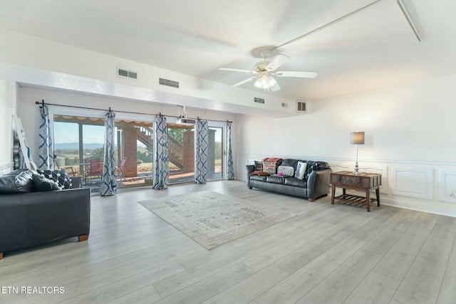 living room with ceiling fan, a healthy amount of sunlight, and light wood-type flooring