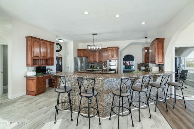 kitchen featuring stainless steel appliances, kitchen peninsula, pendant lighting, a kitchen bar, and light wood-type flooring