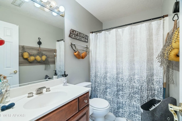 bathroom featuring vanity, a textured ceiling, and toilet