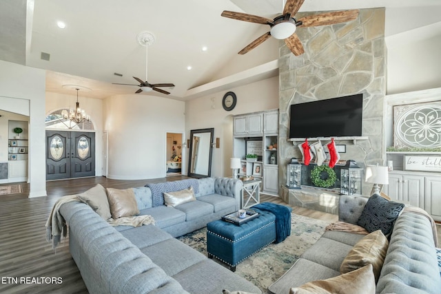 living room featuring ceiling fan with notable chandelier, built in features, wood-type flooring, and high vaulted ceiling